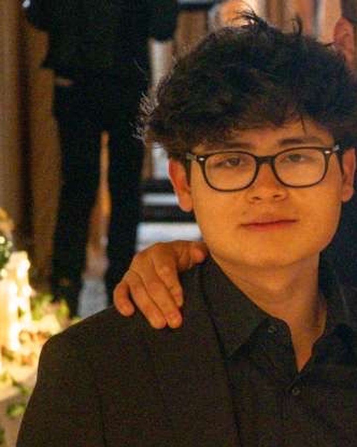 Gus, founder of Gusify, in a black suit and glasses